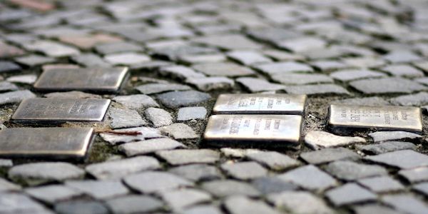 Abgeordnete reinigen Stolpersteine vor dem Hamburger Rathaus