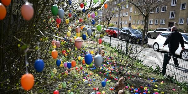 Eine Berliner-Straße mit tausenden bunten Ostereiern an Bäumchen und Wiesen